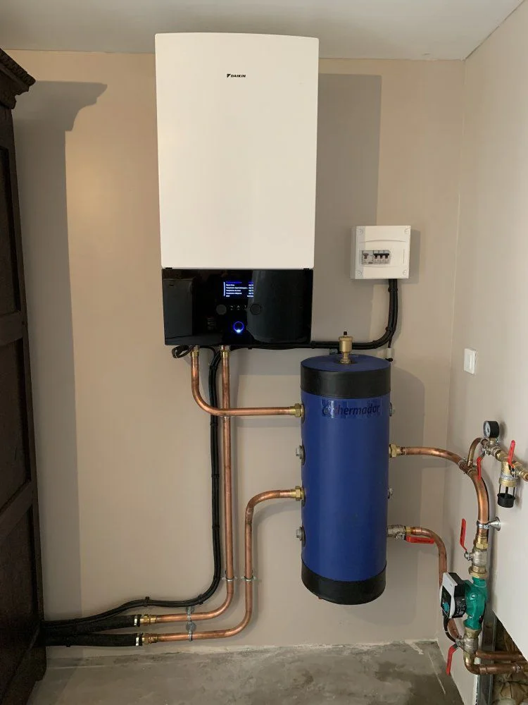 Technicien installant un radiateur de chauffage blanc sur un mur.