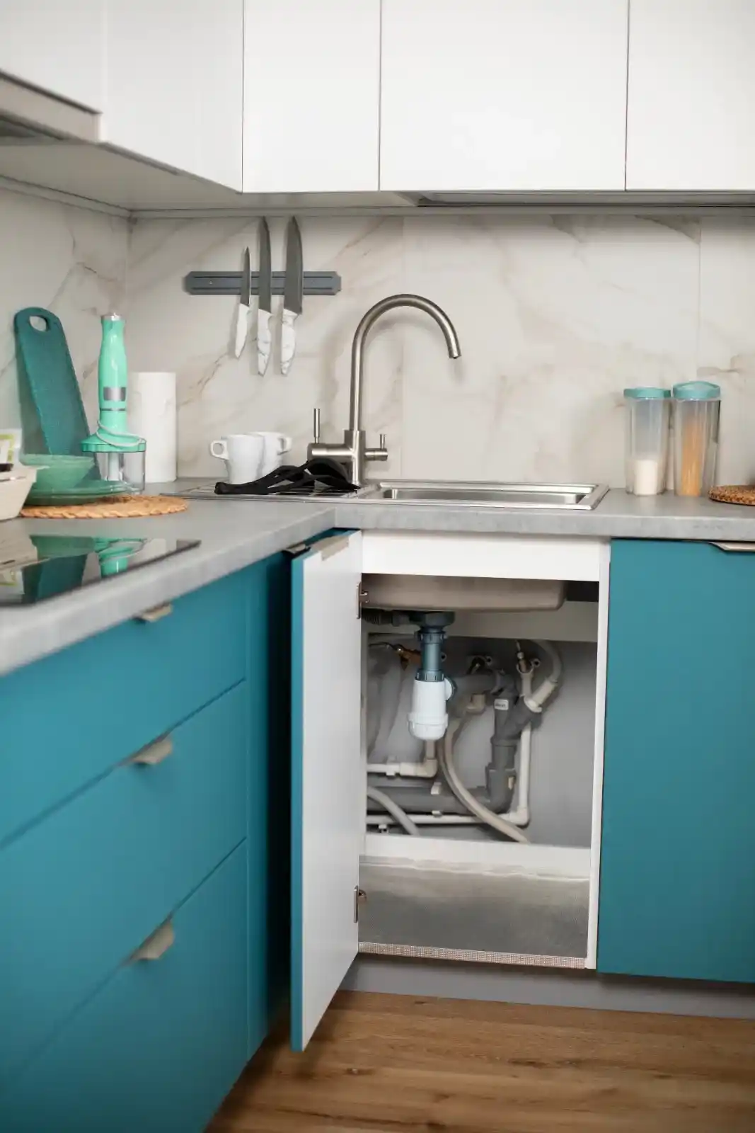 Installation du tuyau d'évacuation dans un meuble sous-évier de cuisine moderne.